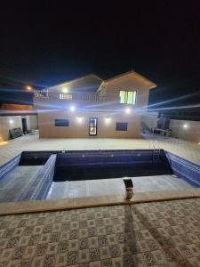 a swimming pool in front of a house at night at Gernatah Farm مزرعة غرناطه in Ajloun