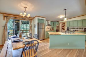 una cocina con armarios verdes y una mesa de madera con sillas. en Modern Keystone Home 4 Mi to Mount Rushmore!, en Keystone
