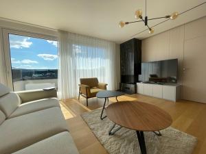 Gega Apartments في Gjakove: غرفة معيشة مع أريكة وطاولة