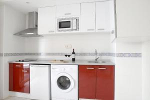 Apartamentos Comfort City في غرناطة: مطبخ مع غسالة ملابس وميكرويف