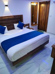 a bedroom with a large bed with blue pillows at Hotel Ozone,Ahmedabad in Ahmedabad