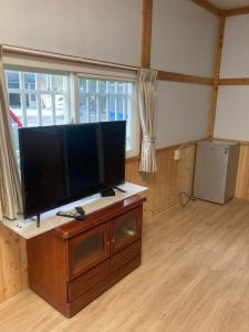 a living room with a flat screen tv on a wooden cabinet at 夏綠房 in Fengyuan