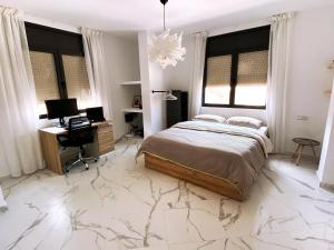 a bedroom with a bed and a desk and a computer at Entire house with private rooftop in Al Hoceïma