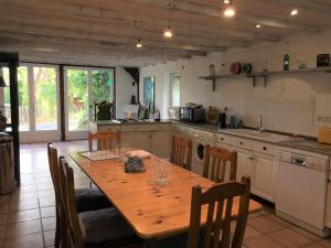 cocina grande con mesa de madera y sillas en Comfortable 3-bed/3-bath holiday home with heated pool and large garden, en Loubès-Bernac