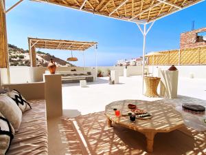 un patio con mesa y vistas al océano en Entire house with private rooftop en Alhucemas