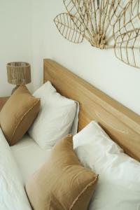 uma cama com almofadas brancas e um lustre em Cottage Sable et Soleil em Anse Marcel 