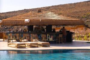 a bar next to a swimming pool next to a resort at BİADA OTELLERİ in Bozcaada