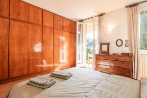 a bedroom with a large bed with two towels on it at Appartamento Lungolago in Domaso +23 photos