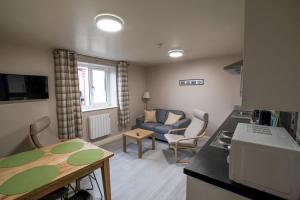a kitchen and living room with a couch and a table at Morecambe Rooms in Morecambe