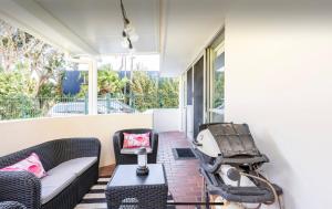 a porch with a couch and chairs and a table at Beachside Beauty at Burleigh Pavilion! in Gold Coast