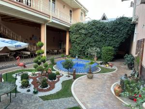 Hotel Billuri Sitora في سمرقند: حديقة فيها مسبح في مبنى