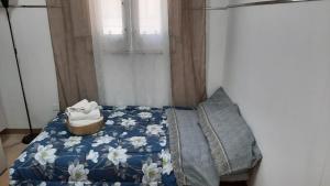 a bedroom with a bed with a blue blanket and a window at Mini Appartamento Centro Niscemi in Niscemi
