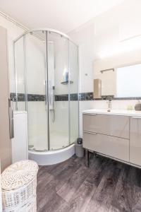 een badkamer met een douche, een wastafel en een bad bij L'Echappée in Chamalières