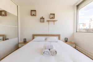 een slaapkamer met een wit bed en handdoeken bij L'Echappée in Chamalières