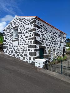 a stone building with a green door on a street at Casa da Lavadia in Canto da Areia