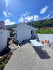 - un bâtiment blanc avec une table et des chaises blanches dans l'établissement Casa da Lavadia, à Canto da Areia