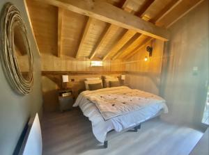uma cama num quarto com tecto em madeira em Le P'tit Curieux em Rupt-sur-Moselle