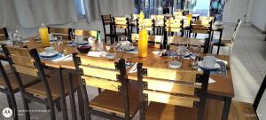 a large wooden table with chairs and glasses on it at Hostal de Los Andes in Rodeo de la Cruz