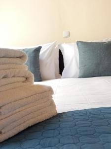 uma pilha de toalhas sentadas em cima de uma cama em Doma Menidi Rooftop Apartment em Menídion