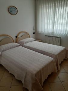 due letti uno accanto all'altro in una stanza di Casa Ilaria a Campolongo