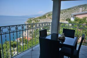 a table and chairs on a balcony with a view of the ocean at Apartment Roby in Senj