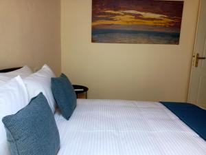 um quarto com uma cama com almofadas azuis e um quadro em Doma Menidi Rooftop Apartment em Menídion