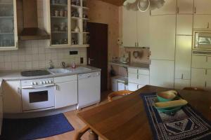 a kitchen with a stove and a sink and a table at Ferienwohnung Forstwiese in Großrosseln