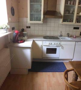 a kitchen with a sink and a stove at Ferienwohnung Forstwiese in Großrosseln