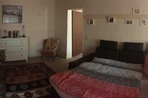 ein Schlafzimmer mit einem Bett, einer Kommode und einem Stuhl in der Unterkunft Ferienwohnung Forstwiese in Großrosseln