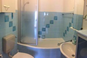 a bathroom with a shower and a toilet and a sink at Ferienwohnung Forstwiese in Großrosseln +4 photos