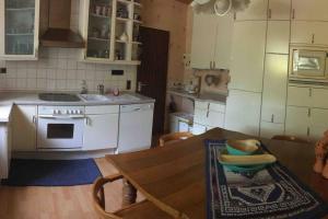 Il comprend une cuisine équipée d'une table et d'une cuisinière. four supérieur dans l'établissement Ferienwohnung Forstwiese, à Großrosseln