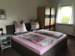 a bedroom with two beds with pink sheets and a window at Ferienwohnung Graupner in Schwarzenberg
