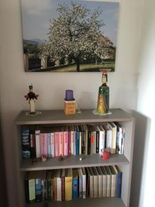 un estante de libros lleno de libros y un árbol en Ferienwohnung Graupner en Schwarzenberg