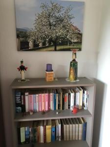 a book shelf filled with books and a tree at Ferienwohnung Graupner in Schwarzenberg