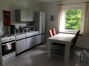 a kitchen with a table and a stove and a window at Ferienwohnung Graupner in Schwarzenberg