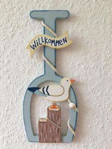 um sinal de madeira com um pássaro num poste em Ferienwohnung Graupner em Schwarzenberg
