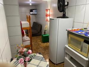 una cocina con nevera y una mesa con flores en Residenciais Maria Flor, en Gramado