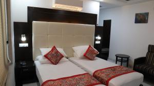 Habitación de hotel con 2 camas con almohadas rojas en VENUS.HOTEL, en Mohali