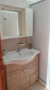 a bathroom with a white sink and a mirror at La Dimora del Frappato di Tenute Senia in Chiaramonte Gulfi