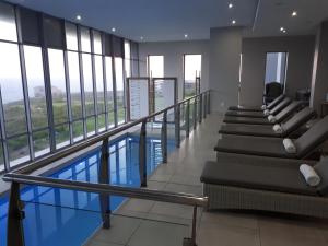 a swimming pool in a building with windows at A Shot Of Luck in Mossel Bay