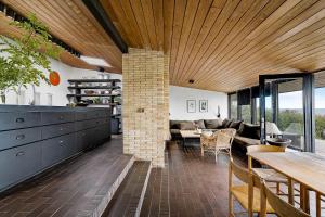 a kitchen and living room with a brick fireplace at Architect Designed Holiday Home With A Beautiful Sea View in Gudhjem