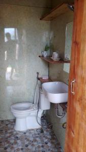 a bathroom with a toilet and a sink at Dốc Nhà Tây in Da Lat