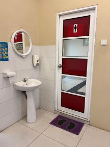 a bathroom with a red door and a sink at BANGI BUSINESS Hotel in Kampong Sungai Ramal Dalam