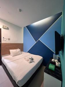 a bedroom with a bed and a blue wall at BANGI BUSINESS Hotel in Kampong Sungai Ramal Dalam