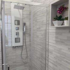 a bathroom with a shower with a glass door at Le Case del Cortile in Catania