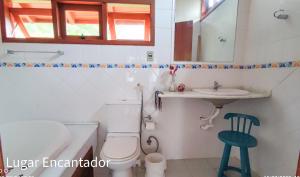 uma casa de banho com um WC, um lavatório e um espelho. em casa Encantadora em Florianópolis