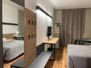 a hotel room with two beds and a desk at Hotel 10 Curitiba in Curitiba