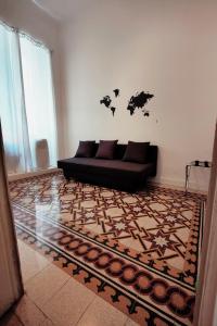 a living room with a black couch and a rug at AcB Vaticano Suites in Rome