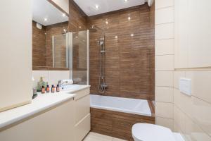 e bagno con doccia, servizi igienici e lavandino. di Osiedle Avia Harmonious Apartment with Balcony & Parking Cracow by Renters Prestige a Cracovia