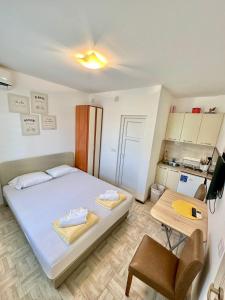 a small bedroom with a bed and a table at Montenegrina Apartment in Budva